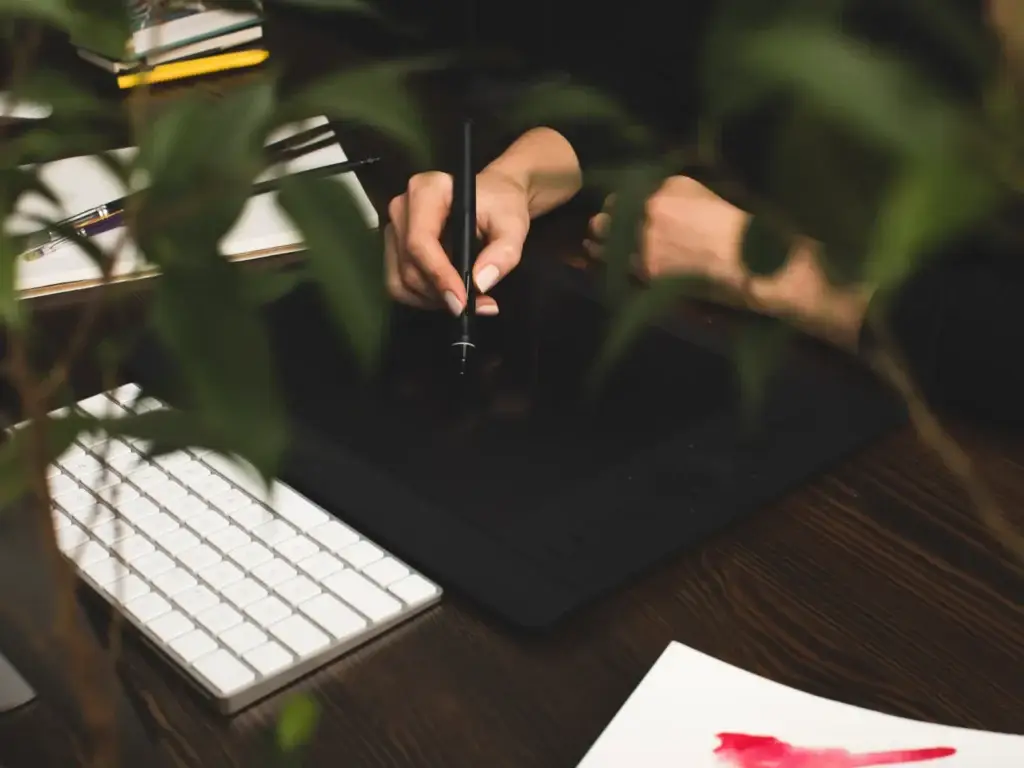 Designer drawing on a graphics tablet at a wooden desk